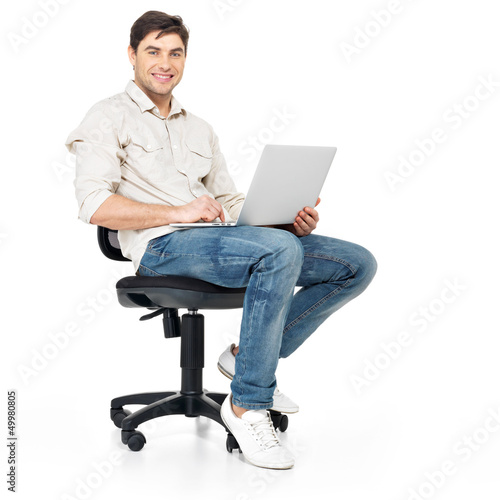 Photo: man working on laptop sits on the chair man working on laptop sits on the chair