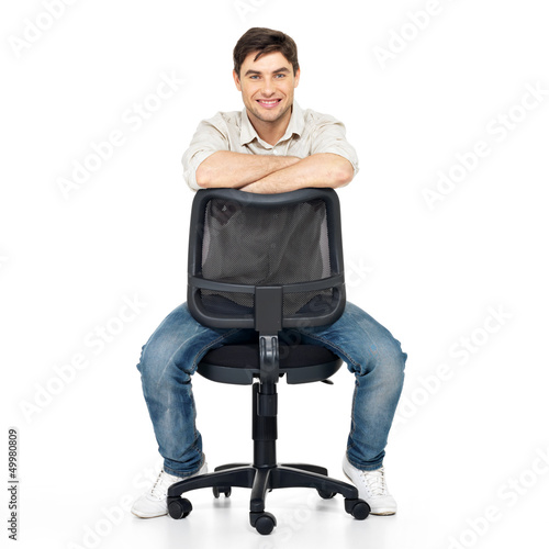 Photo: Portrait of smiling happy man sits on office chair Portrait of smiling happy man sits on office chair