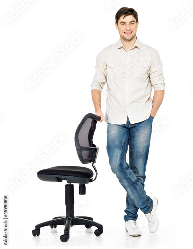 Photo: happy man stands near the office chair happy man stands near the office chair