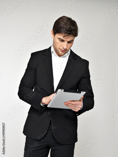 Photo: businessman in black suit with pad at studio businessman in black suit with pad at studio