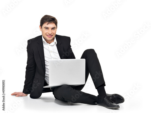 Photo: young happy businessman working on laptop young happy businessman working on laptop