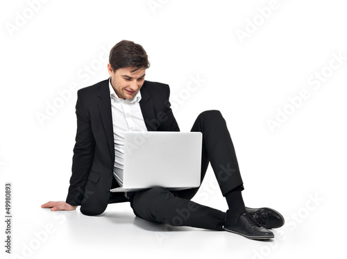 Photo: young happy businessman working on laptop young happy businessman working on laptop