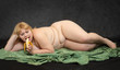 Naked blonde woman eating fresh ripe banana. Funny diet concept.