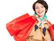 Happy woman with shopping bags in beige autumn coat