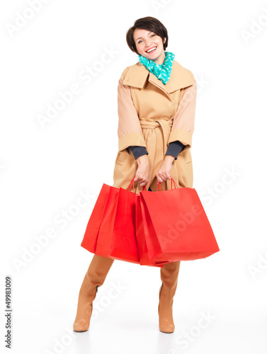 Photo: Portrait of happy woman with shopping bags in autumn coat Portrait of happy woman with shopping bags in autumn coat