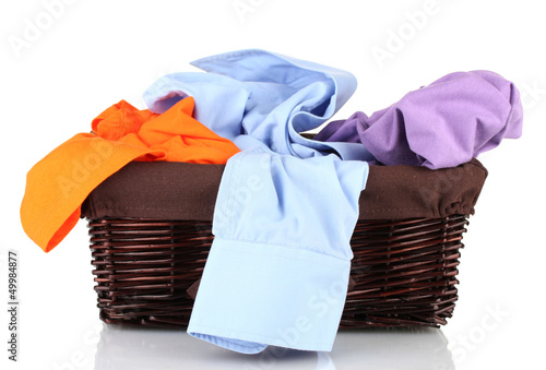 Photo: Bright clothes in laundry basket, isolated on white Bright clothes in laundry basket, isolated on white