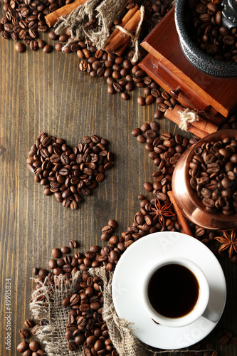 Photo: Cup of coffee, pot and grinder on wooden background Cup of coffee, pot and grinder on wooden background