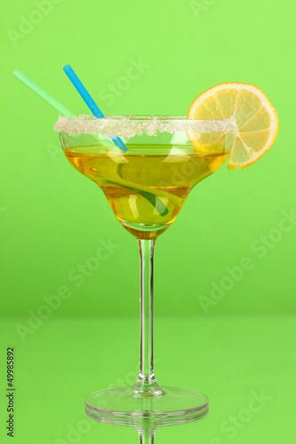 Photo: Yellow cocktail in glass on color background Yellow cocktail in glass on color background