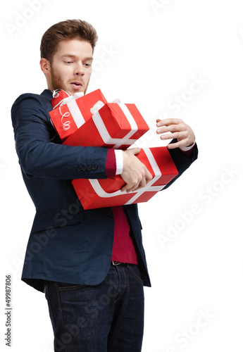 Photo: Young man carries a great amount of presents Young man carries a great amount of presents