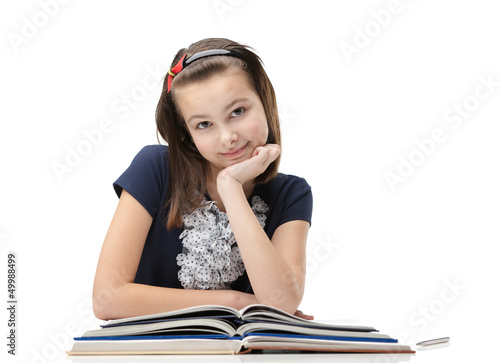 Photo: Smiley schoolgirl studies useful material, isolated Smiley schoolgirl studies useful material, isolated