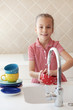 Little girl washing the dishes