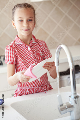 Photo: Little girl washing the dishes Little girl washing the dishes