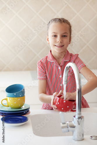 Photo: Little girl washing the dishes Little girl washing the dishes