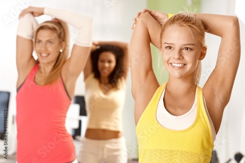 Photo: Pretty girl exercising in group Pretty girl exercising in group