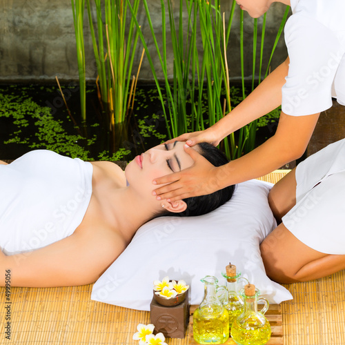 Photo: Asian woman having a massage in tropical setting Asian woman having a massage in tropical setting
