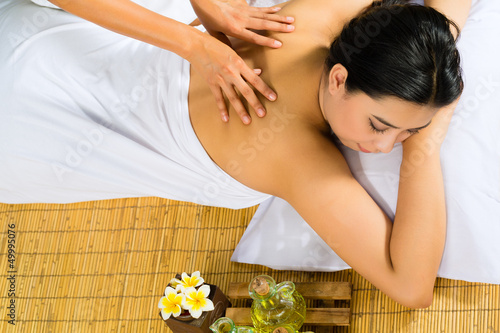 Photo: Asian woman having a massage in tropical setting Asian woman having a massage in tropical setting
