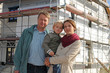 Junge Familie vor Eigenheim