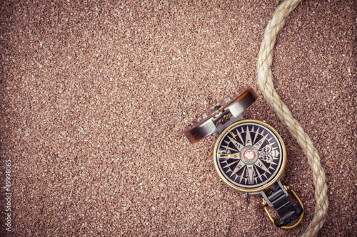 Photo: Vintage compass on sand background Vintage compass on sand background
