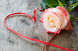 schöne Rose mit Herz auf Holzhintergrund
