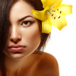 beautiful spa young multiracial woman with yellow flower lily in