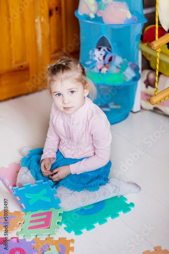 Photo: Cute little girl solving puzzles Cute little girl solving puzzles