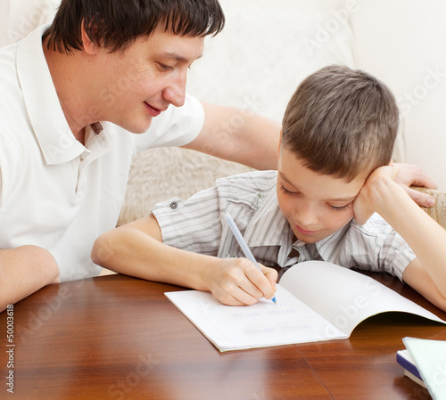 Photo: Father helping son do homework Father helping son do homework