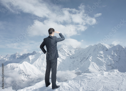 Photo: businessman looking to winter mountains businessman looking to winter mountains