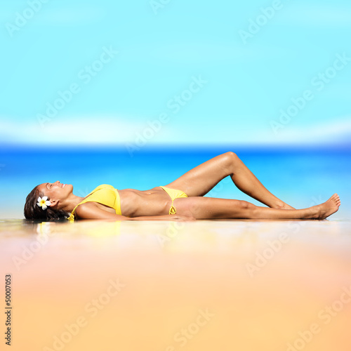 Photo: Beach vacation holiday woman in a bikini relaxing Beach vacation holiday woman in a bikini relaxing