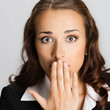 Businesswoman covering mouth, over gray