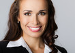 Happy smiling young businesswoman, on gray