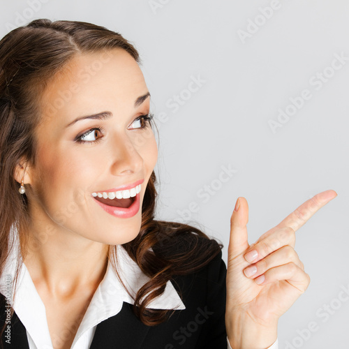 Photo: Businesswoman showing, over gray Businesswoman showing, over gray