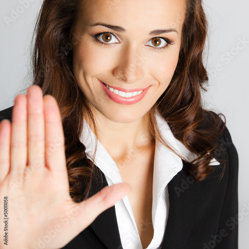 Photo: Businesswoman with stop gesture, over gray Businesswoman with stop gesture, over gray
