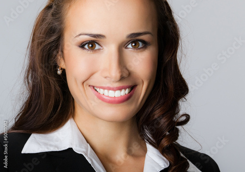 Photo: Happy smiling young businesswoman, on gray Happy smiling young businesswoman, on gray