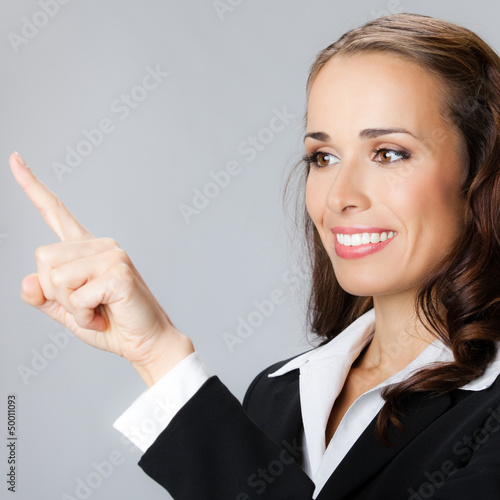Photo: Businesswoman showing, over gray Businesswoman showing, over gray