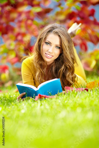 Photo: beautiful girl with book in the spring park beautiful girl with book in the spring park