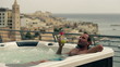 Young man drinking exotic coctail in hot tub , slow motion shot a