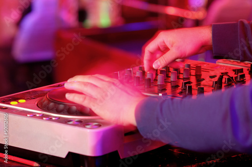 Photo: Dj mixes the track in the nightclub at a party Dj mixes the track in the nightclub at a party