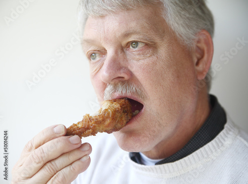 Photo: senior man eating fried chicken leg senior man eating fried chicken leg