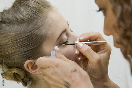 Photo: Jeune femme se faisant maquiller Jeune femme se faisant maquiller