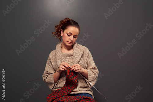 Photo: young woman is knitting young woman is knitting