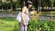 young pregnant woman comes to flower bed