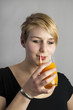 Frau trinkt ein Glas Multivitaminsaft