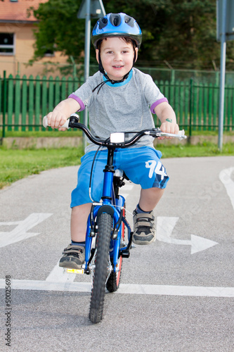 Photo: Baby boy on traffic playground for childs with crash helmet Baby boy on traffic playground for childs with crash helmet