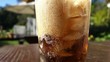 Pouring cola in glass with ice cubes
