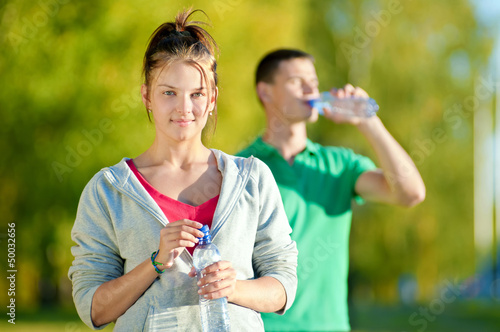 Photo: Man and woman drinking from bottle Man and woman drinking from bottle