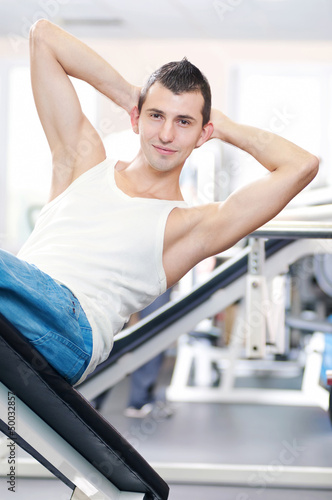 Photo: Young man doing exercises at gym Young man doing exercises at gym