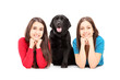 Two young females lying and posing with a dog