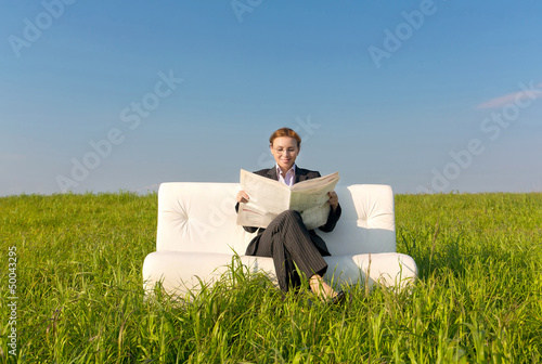 Photo: Business woman reading a newspaper Business woman reading a newspaper
