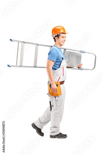 Photo: Full length portrait of a repairman with a helmet carrying a lad Full length portrait of a repairman with a helmet carrying a lad