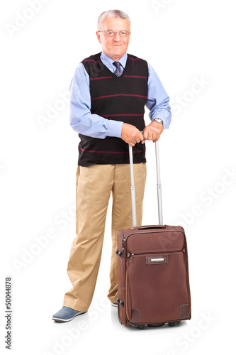 Photo: Full length portrait of a senior gentleman standing with a trave Full length portrait of a senior gentleman standing with a trave